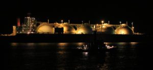 Ein beleuchteter LNG-Tanker bei nacht im Hfen