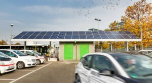 Großer Parkplatz mit E-Autos und Solarladeanlage