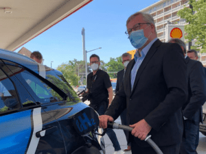 Minister Althusmann betankt ein Wasserstoff-Fahrzeug.