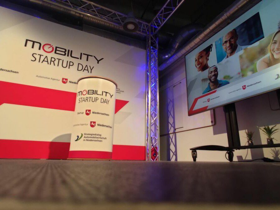 Bühne beim Mobility Startup Day 2021 mit Logo, Bildschirm und Banner.