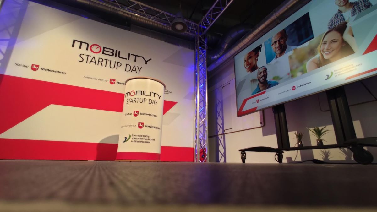 Bühne beim Mobility Startup Day 2021 mit Logo, Bildschirm und Banner.