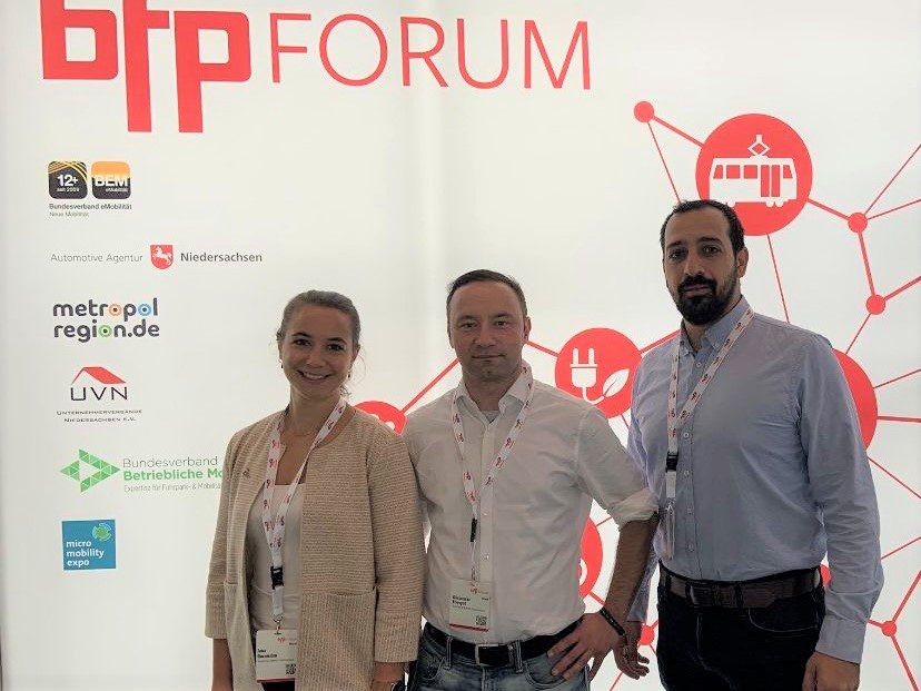 Jana Dornieden, Olexander Filevych und Barkin Özkaya vor einer Stellwand mit der Aufschrift bfp-Forum und weiteren Logos.