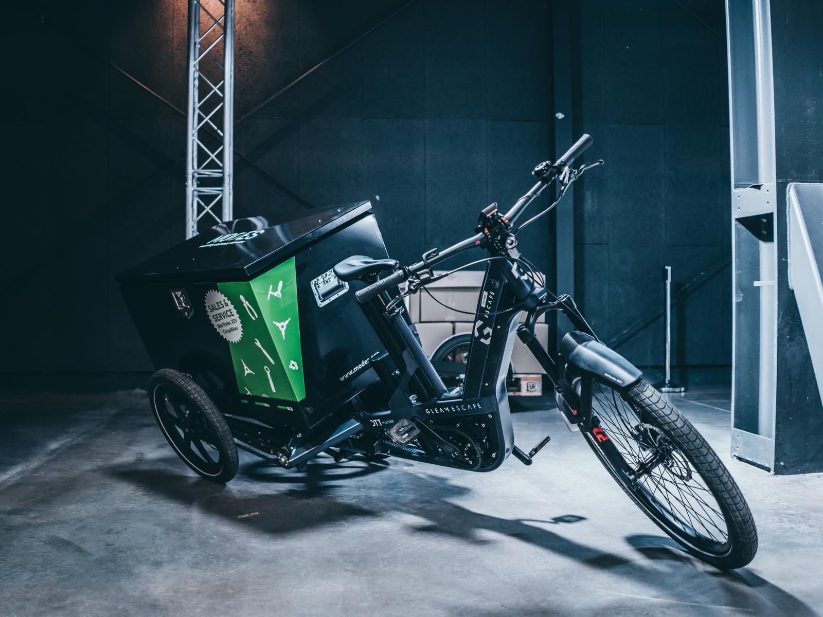 Ein schwarzes E-Cargo Bike mit Transportkiste im hinteren Bereich