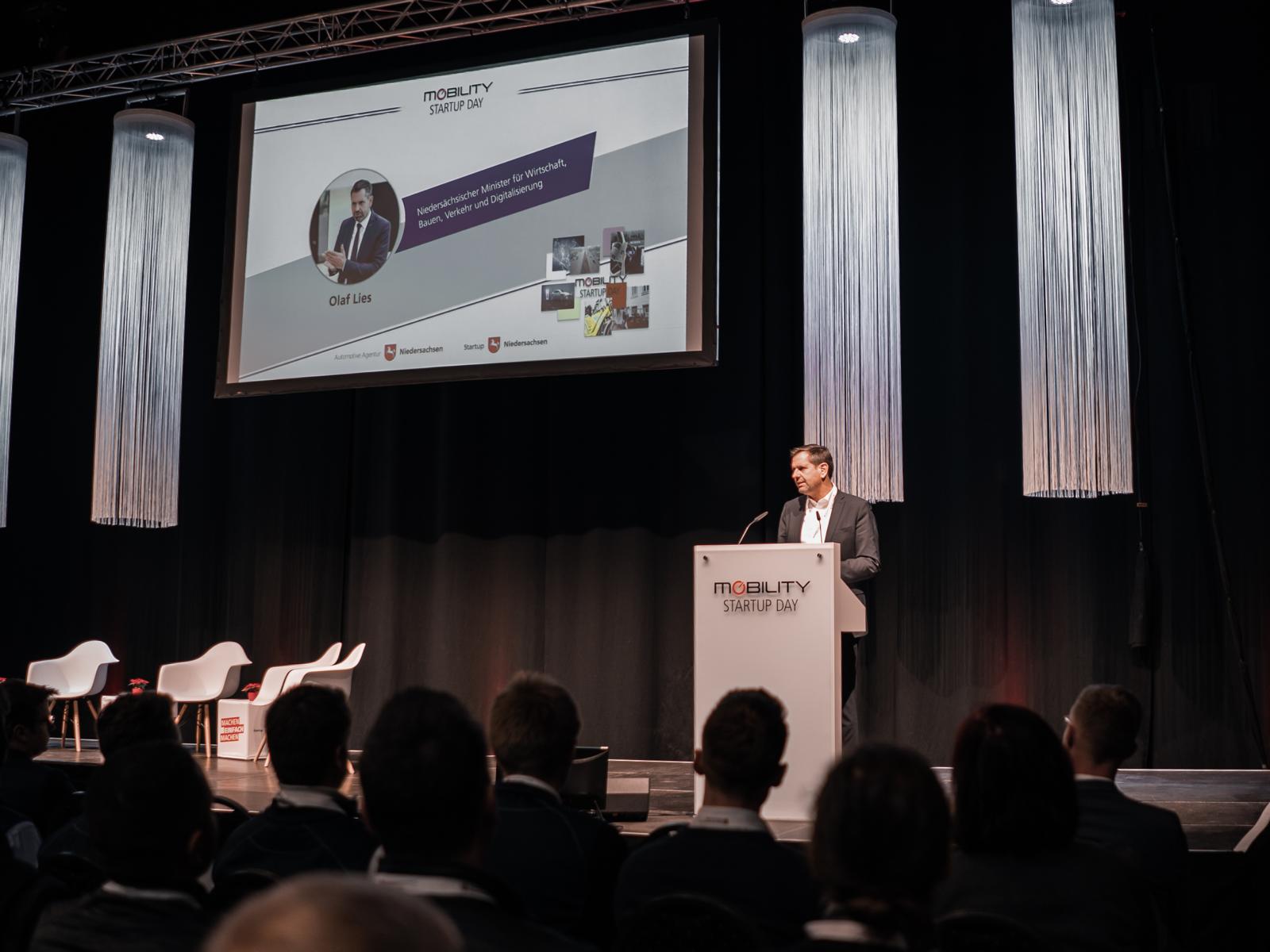 Niedersachsens Wirtschaftsminister Olaf Lies eröffnet am Rednerpult auf der Bühne den Mobility Startup Day.