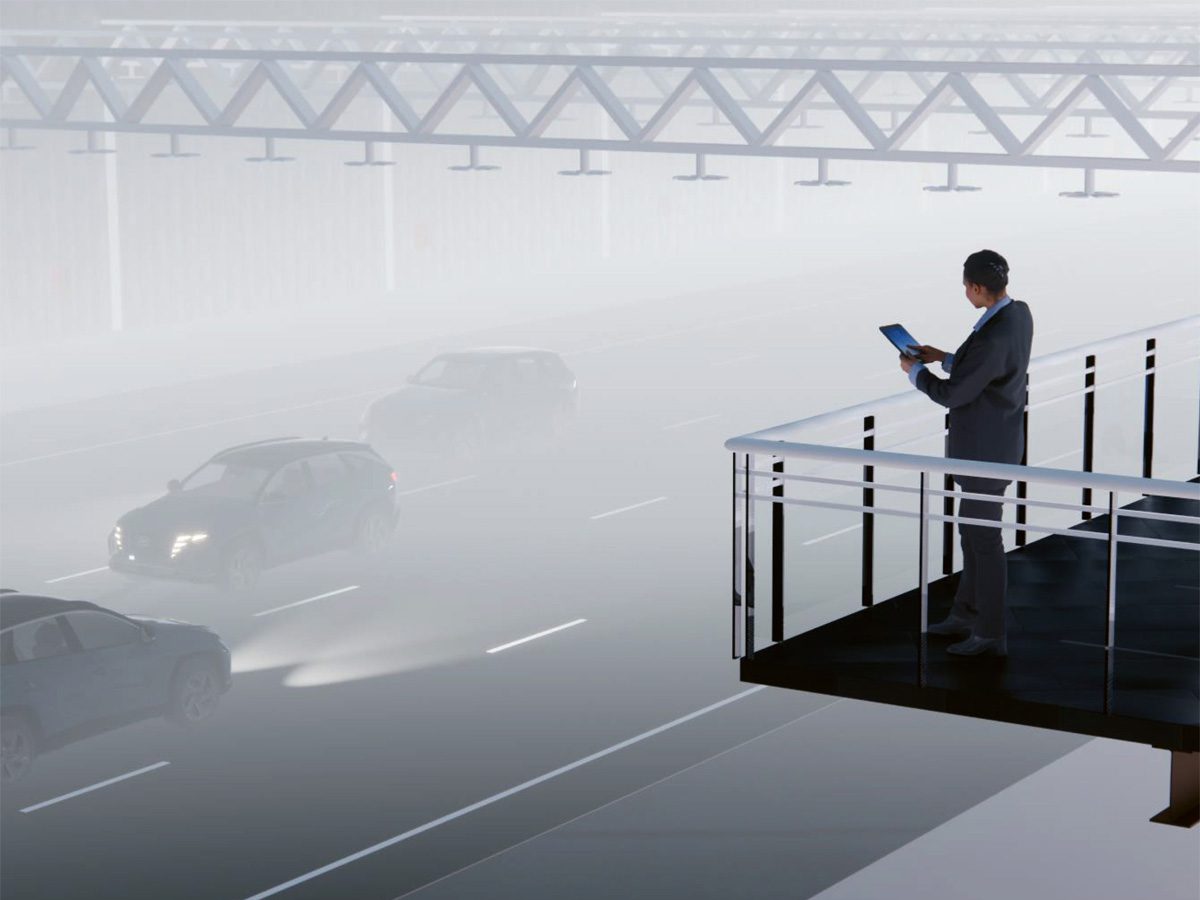 Simulation von fahrenden Autos im Nebel, die von einem Mann auf einem Balkon per Tablet beobachtet wird