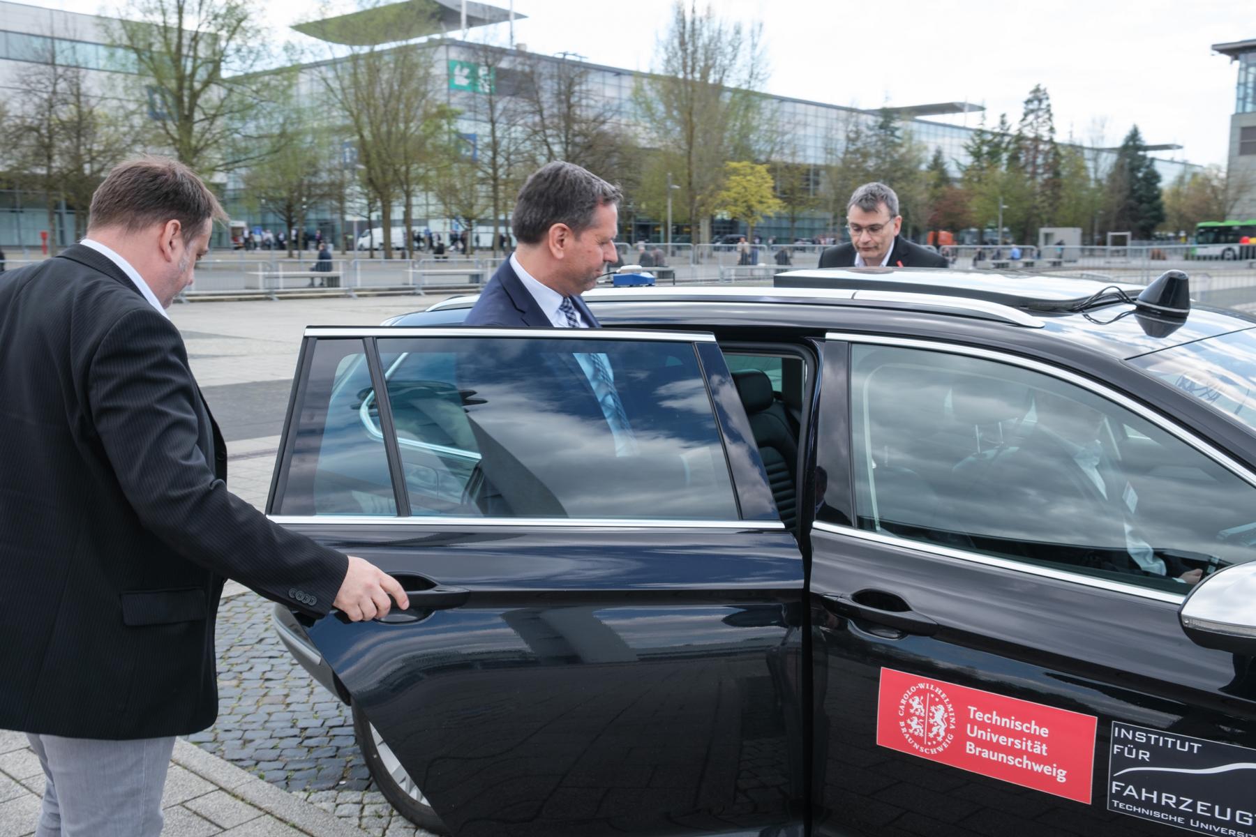Wirtschaftsminister Lies steigt auf dem Messegelände in eine Auto ein.